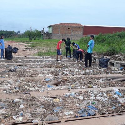 Jóvenes salieron a limpiar rejilla que es causante de inundación