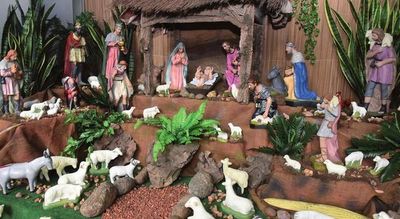El tradicional pesebre se opaca por las luces de un árbol de pino