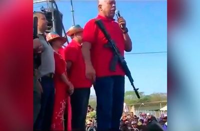 Diputado chavista da discurso con un fusil colgado en el cuello